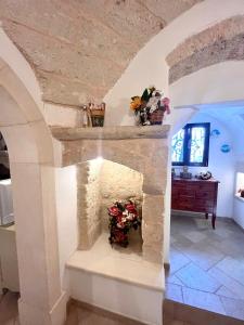 オストゥーニにあるVILLA GAIAの花瓶付きの石造りの暖炉のある部屋