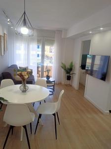 ein Wohnzimmer mit einem weißen Tisch und Stühlen in der Unterkunft Apartamento Granada-Ronda in Granada