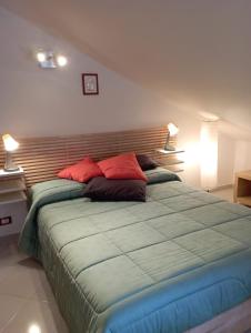 - une chambre avec un grand lit et 2 oreillers rouges dans l'établissement Terrazza M & G, à Ortona