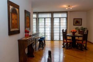 a living room with a dining room table and chairs at Colonial Charm. Experience historic Quito. in Quito