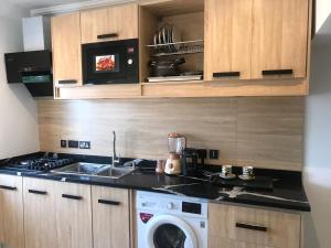 een keuken met een spoelbak en een wasmachine bij S.K PLAZA in Oost-Legon +32 foto's