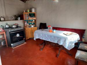 een kleine keuken met een tafel en een fornuis bij Casa de Campo-Hospedaje Munay Wasi in Tarma