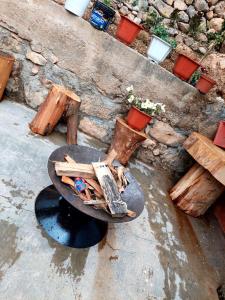 a fire pit with logs and a table and benches at Casa de Campo-Hospedaje Munay Wasi in Tarma