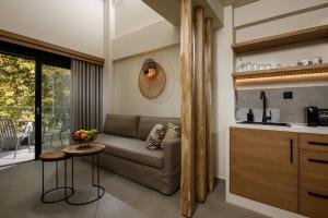a living room with a couch and a table at Ammothines Beach Suites in Chrysi Ammoudia