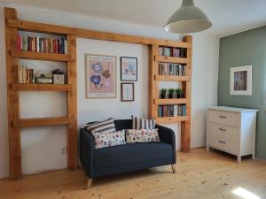 a living room with a blue couch and book shelves at Chata Kolmanovci in Oščadnica