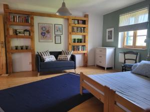 a living room with a blue couch and a chair at Chata Kolmanovci in Oščadnica