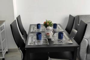 a black table with a vase and blue cups on it at Sul mare Atlantico intero appartamento con piscina in Arona +23 photos