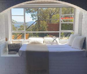 a bed in a room with a large window at Sweeping views of Hanging Rock and Cobaw Ranges in Mount Macedon