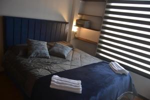 a bedroom with a bed with two towels on it at SLH Boutique Guesthouse in Pasto