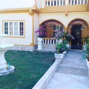 a house with two vases of flowers in the yard at Windbreak Villa in Buff Bay