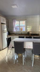 eine Küche mit einem Tisch und Stühlen sowie einem Kühlschrank in der Unterkunft Casa - Florianópolis, ponta das canas in Florianópolis