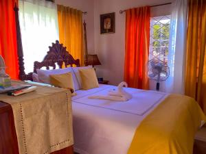 um quarto com uma cama com dois cisnes em Windbreak Villa em Buff Bay