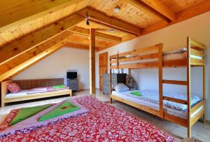 ヴェルケー・ロシニにあるSrub Losinyの木製天井のドミトリールームの二段ベッド2台分です。