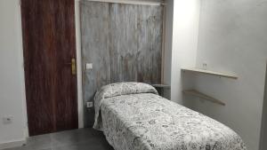 a bedroom with a bed and a wooden door at TAO OLOT in Olot