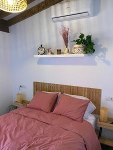 a bedroom with a bed with pink sheets and a shelf at Hermoso flat de playa in Valencia