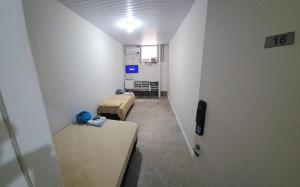 a room with two beds and a room with a hallway at Pousada Aqua in Campo Grande