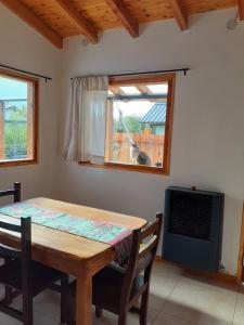 a dining room table with a dog looking out the window at La casa de arriba in El Bolsón