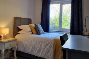 1 dormitorio con 1 cama, escritorio y ventana en Westland Retreat - Magherafelt - Mid Ulster - NITB Approved, en Magherafelt