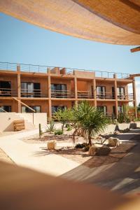 an apartment building with palm trees in front of it at Baja Temple in Todos Santos