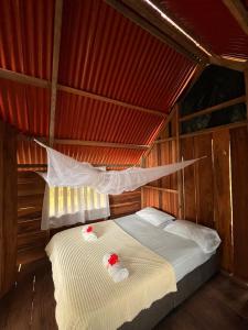 a bed in a room with a red roof at El Retoño del Negro Gozón in Nuquí