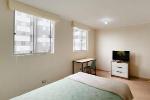 利馬的住宿－Habitación moderna y segura cerca al Aeropuerto，一间卧室配有一张床、一张书桌和一台电视