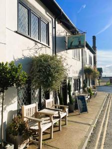 un gruppo di panchine seduti fuori da un edificio di Beautiful Immaculate Aldeburgh cottage, sunny outdoor space, free parking - easy walk to beach & town ad Aldeburgh Altre 33 foto
