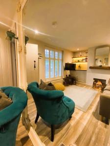 ein Wohnzimmer mit einem grünen Stuhl und einer Couch in der Unterkunft Stunning Coastal Cottage with free parking - easy stroll to town & beach in Aldeburgh