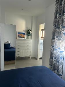 sypialnia z łóżkiem i komodą z lustrem w obiekcie Balcon San Rafael w Kordobie