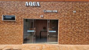 an entrance to a brick building with a glass door at Pousada Aqua in Campo Grande