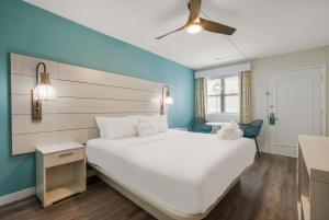 ein Schlafzimmer mit einem weißen Bett und einer blauen Wand in der Unterkunft Hotel Cabana Oceanfront/Boardwalk in Wildwood