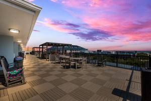 un patio con mesas y sillas en la playa en Hotel Cabana Oceanfront/Boardwalk en Wildwood