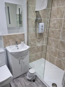 a bathroom with a shower and a toilet and a sink at Lexham Hotel in Blackpool