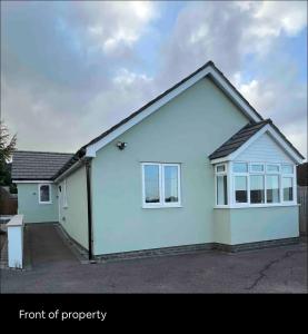 a white house with a front of property at Green 3 bed bungalow with en-suite and parking in Felton