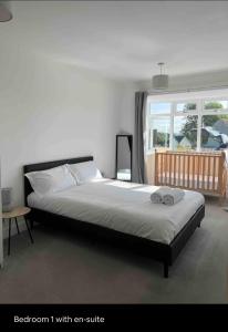 a bedroom with a bed with anc sofa and a window at Green 3 bed bungalow with en-suite and parking in Felton