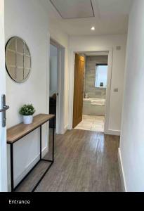 a living room with a table and a mirror at Green 3 bed bungalow with en-suite and parking in Felton