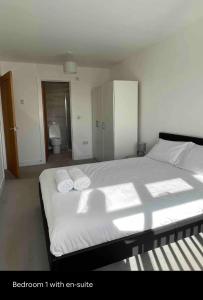 1 dormitorio con 1 cama con 2 toallas en Green 3 bed bungalow with en-suite and parking en Felton