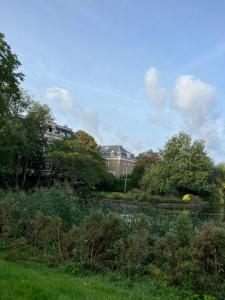 a house on a hill with trees and bushes at Beautiful new apartment Antwerpen in Antwerp