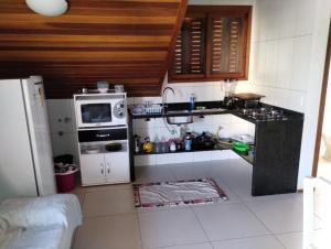 a small kitchen with a refrigerator and a microwave at Flat Theobald in Três Coroas