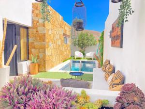 a patio with a pool and some plants at Villa Zephyr con piscina privada. in Gran Tarajal