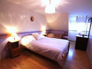 um quarto com uma cama branca com 2 mesas e 2 candeeiros em Gîte Orbey, 4 pièces, 6 personnes - FR-1-744-26 em Orbey