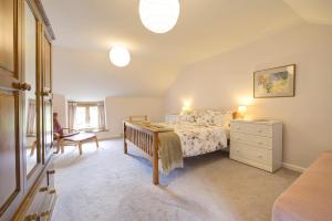 a bedroom with a bed and a dresser at Historic cottage in the beautiful Wye Valley in Saint Briavels