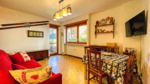 ein Wohnzimmer mit einem roten Sofa und einem Tisch in der Unterkunft Appartamento Einaudi 11 - Affitti Brevi Italia in Bardonecchia