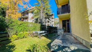 a building with a bench in front of a yard at Appartamento Einaudi 11 - Affitti Brevi Italia in Bardonecchia +12 photos