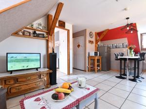 ein Wohnzimmer mit Fernseher und Tisch in der Unterkunft Gîte charmant au calme, 2 personnes, proche vignobles et châteaux, animaux acceptés, terrasse jardin - FR-1-744-33 in Bergheim