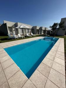 une grande piscine bleue en face d'une maison dans l'établissement Los Olivos, à Federación