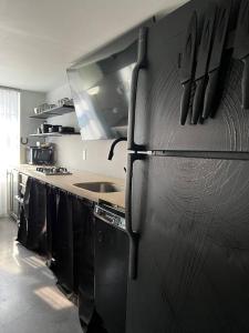 a kitchen with a black refrigerator and a sink at Unique Style Apartment in Asbury Park