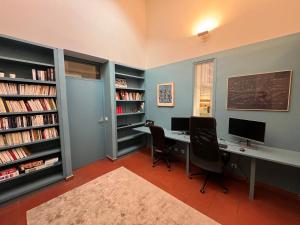 una oficina con escritorio y 2 sillas y libros en Grande Maison avec jardin et parking proche de Paris en Issy-les-Moulineaux