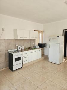 uma cozinha com electrodomésticos brancos e um frigorífico branco em Center Cruz del Eje em Cruz del Eje