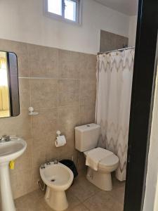 a bathroom with a toilet and a sink at Center Cruz del Eje in Cruz del Eje