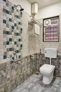 a bathroom with a toilet and a tiled wall at hotel Fortune Suites Baner-- Indian nationals only in Pune